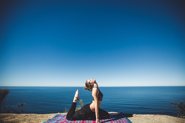 a woman performing yoga fitness exercises outdoor overlooking the sea